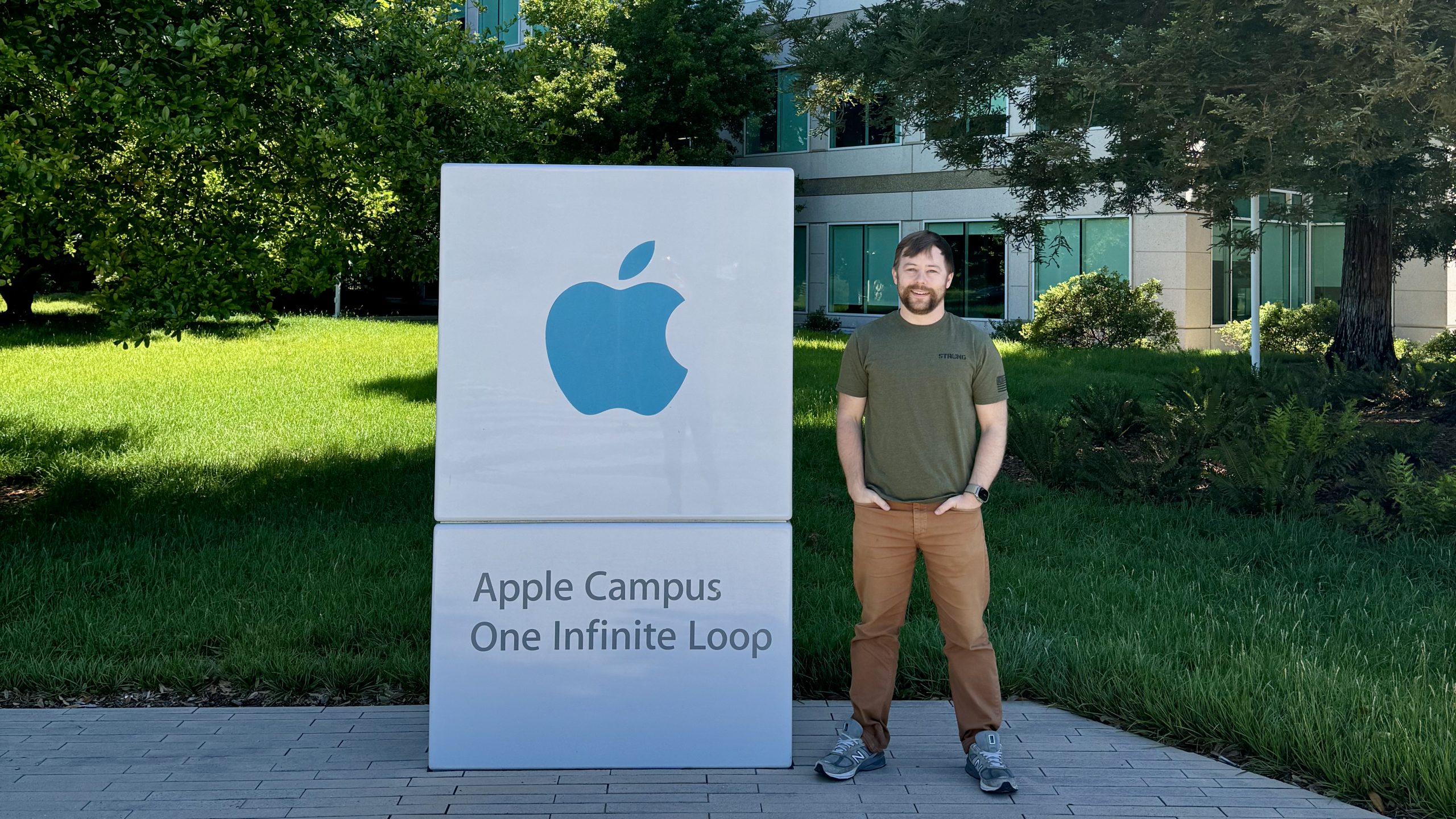 Reid standing in front of the Apple Campus sign at One Infinite Loop